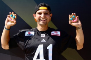 Hamilton Tiger-Cats pose with Tim Hortons Smile Cookies, purchases made that day support local charities